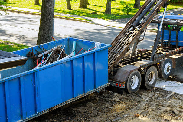 Building trash is loaded into metal dumpster containers during construction at a Danbury, CT house renovation.