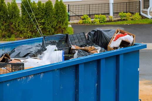 A waste dumpster is used for household disposal in Danbury, CT.